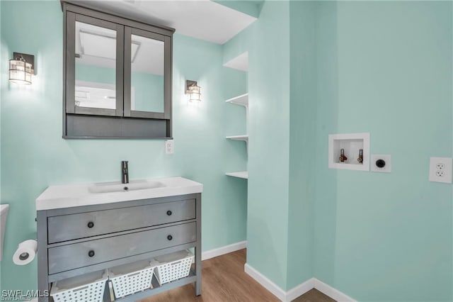 bathroom with vanity, wood finished floors, and baseboards