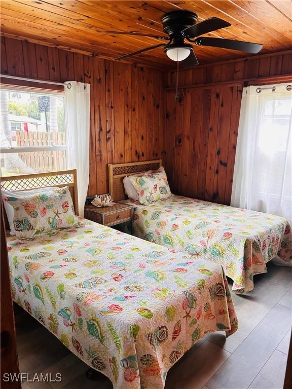 bedroom featuring wooden ceiling, wood walls, and wood finished floors