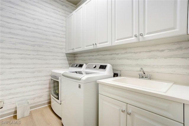 11607 Periwinkle Dr, Naples, FL 34120 - clothes washing area with a sink, washing machine and dryer, light wood-type flooring, and cabinet space