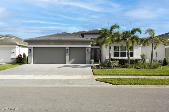 11607 Periwinkle Dr, Naples, FL 34120 - view of front of property featuring a garage, stucco siding, a tile roof, decorative driveway, and a front yard