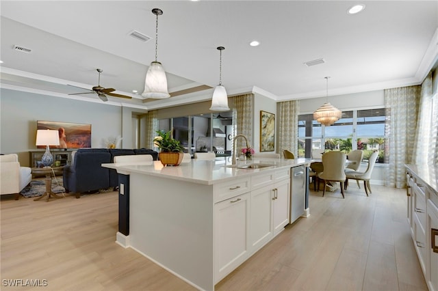 11607 Periwinkle Dr, Naples, FL 34120 - kitchen featuring ornamental molding, visible vents, a sink, open floor plan, and light wood-type flooring