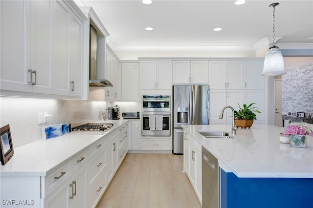 11607 Periwinkle Dr, Naples, FL 34120 - kitchen with a sink, wall chimney range hood, light wood-type flooring, hanging light fixtures, and appliances with stainless steel finishes