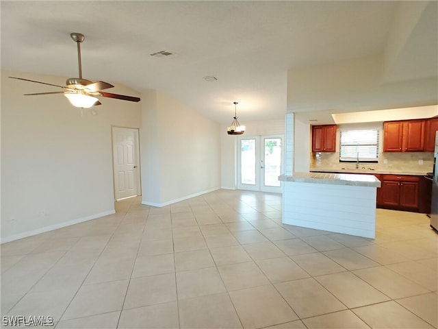316 SE Santa Barbara Pl, Cape Coral, FL 33990 - kitchen with visible vents, baseboards, open floor plan, light countertops, and backsplash