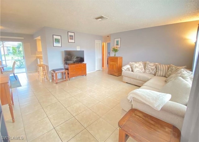 living area featuring light tile patterned flooring and a textured ceiling