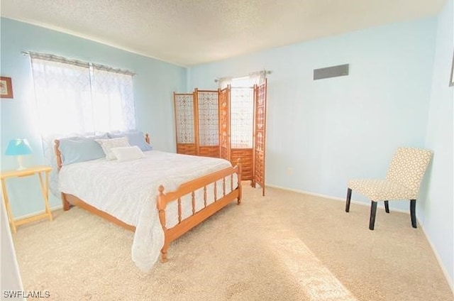 bedroom with carpet, a textured ceiling, and baseboards