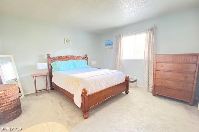 bedroom featuring light carpet and a textured ceiling