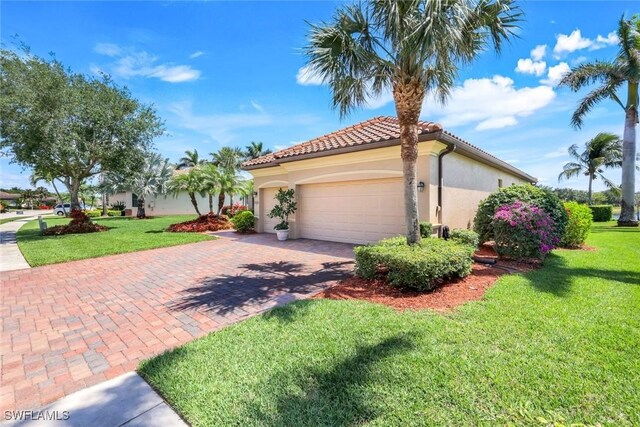 view of side of home featuring an attached garage, a yard, stucco siding, and decorative driveway