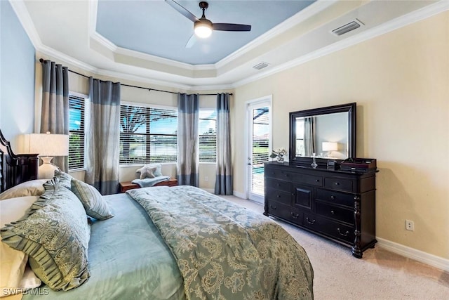 carpeted bedroom with crown molding, visible vents, baseboards, and a tray ceiling