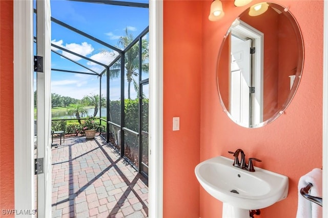 bathroom featuring a sink, a water view, and expansive windows