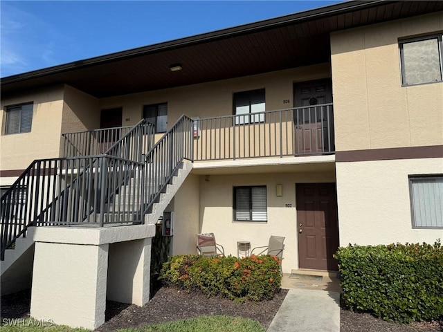 view of property with cooling unit and stairs