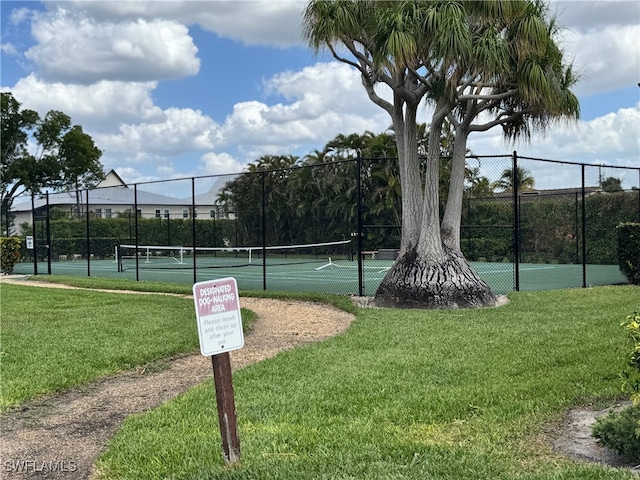 view of sport court featuring fence and a yard