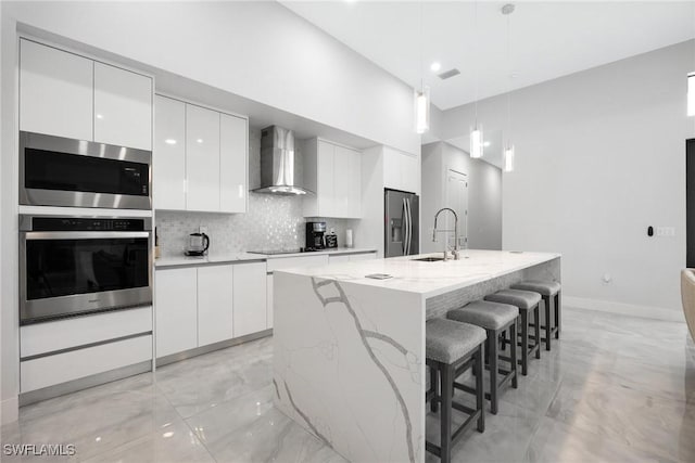 302 NW 1st St, Cape Coral, FL 33993 - kitchen with wall chimney range hood, modern cabinets, appliances with stainless steel finishes, white cabinetry, and a high ceiling