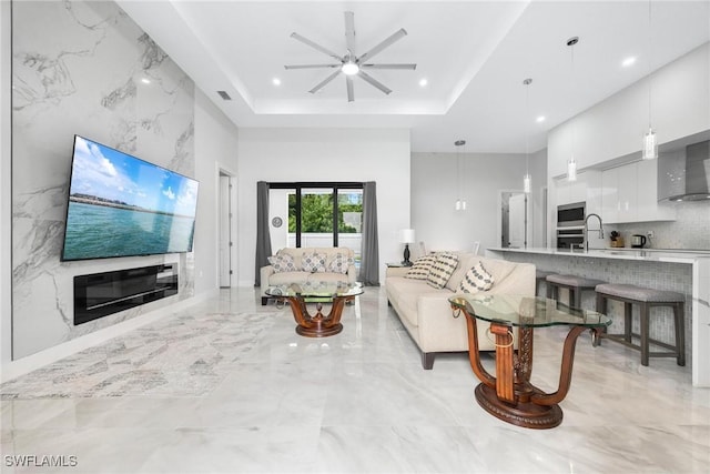 302 NW 1st St, Cape Coral, FL 33993 - living area with light marble finish flooring, a ceiling fan, recessed lighting, and a raised ceiling