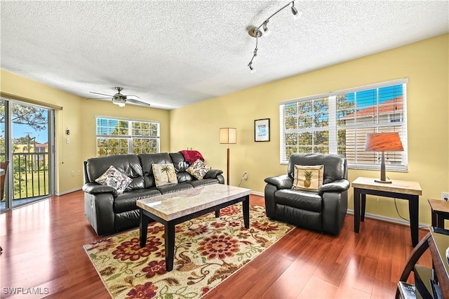 living room with a textured ceiling, ceiling fan, and wood finished floors