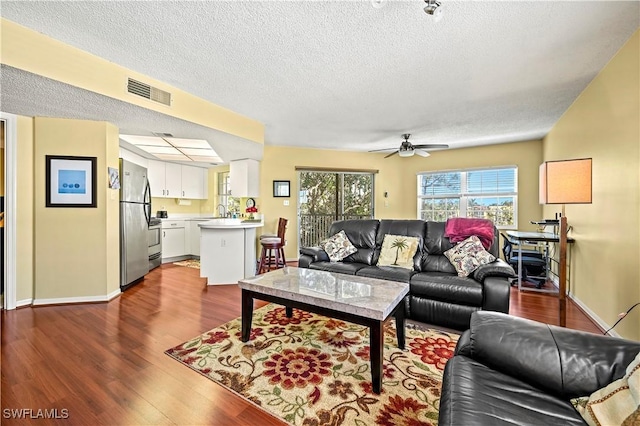 481 Quail Forest Blvd Unit B310, Naples, FL 34105 - living room featuring dark wood-style flooring, a textured ceiling, visible vents, and a ceiling fan
