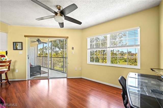 office area with a textured ceiling, ceiling fan, and wood finished floors