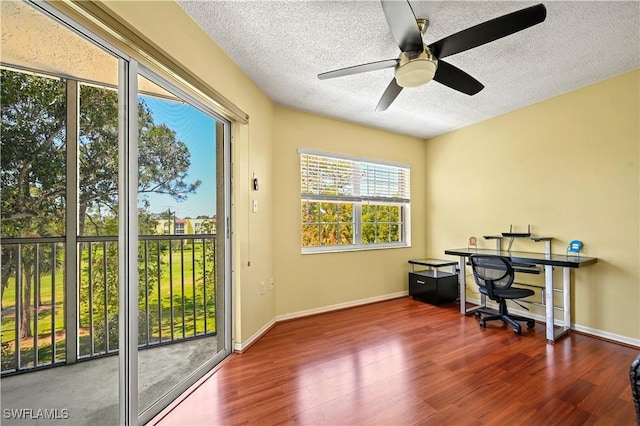 office space with baseboards, a textured ceiling, ceiling fan, and wood finished floors