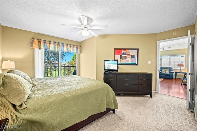bedroom featuring ceiling fan, access to outside, light carpet, and a textured ceiling