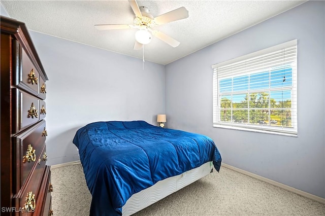 bedroom featuring carpet floors, baseboards, a ceiling fan, and a textured ceiling