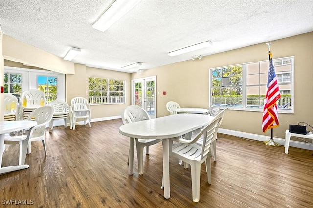 481 Quail Forest Blvd Unit B310, Naples, FL 34105 - dining area with a textured ceiling, baseboards, and wood finished floors