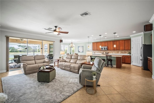 8629 Julia Ln, Naples, FL 34114 - living room with crown molding, light tile patterned floors, visible vents, and ceiling fan with notable chandelier