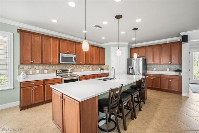 8629 Julia Ln, Naples, FL 34114 - kitchen featuring crown molding, an island with sink, visible vents, a sink, and stainless steel appliances
