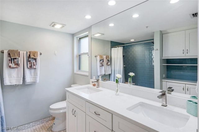 full bath featuring a sink, toilet, tiled shower, and visible vents