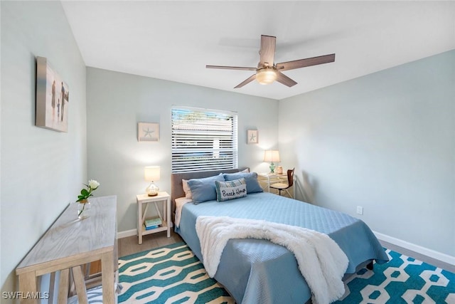 bedroom featuring baseboards, a ceiling fan, and wood finished floors