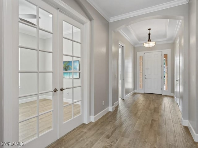 foyer featuring baseboards, french doors, wood finished floors, and arched walkways