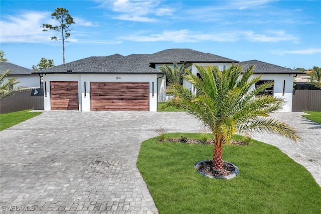1041 Embers Pkwy W, Cape Coral, FL 33993 - view of front of property with stucco siding, fence, an attached garage, decorative driveway, and a front lawn
