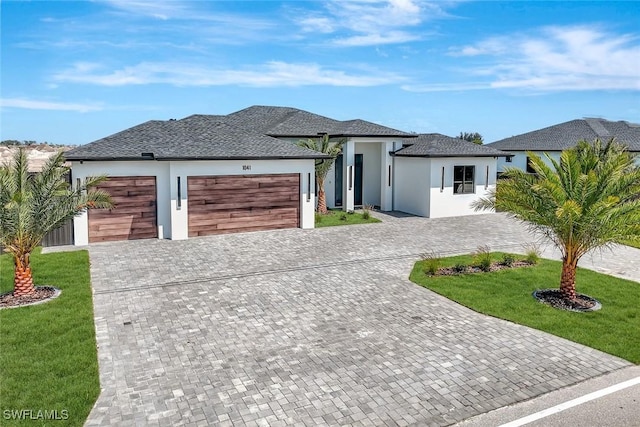 1041 Embers Pkwy W, Cape Coral, FL 33993 - view of front facade with a front yard, roof with shingles, stucco siding, an attached garage, and decorative driveway