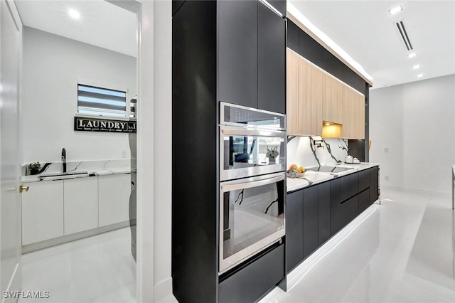 1041 Embers Pkwy W, Cape Coral, FL 33993 - kitchen with dark cabinetry, modern cabinets, light stone countertops, and visible vents