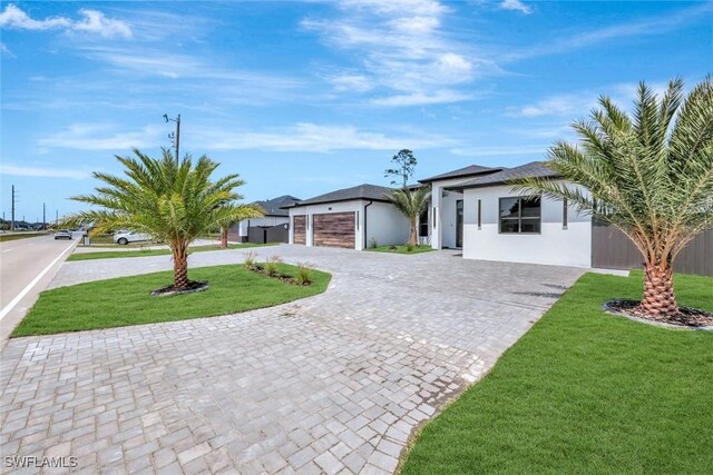 1041 Embers Pkwy W, Cape Coral, FL 33993 - view of front of home featuring a front yard, an attached garage, stucco siding, and curved driveway