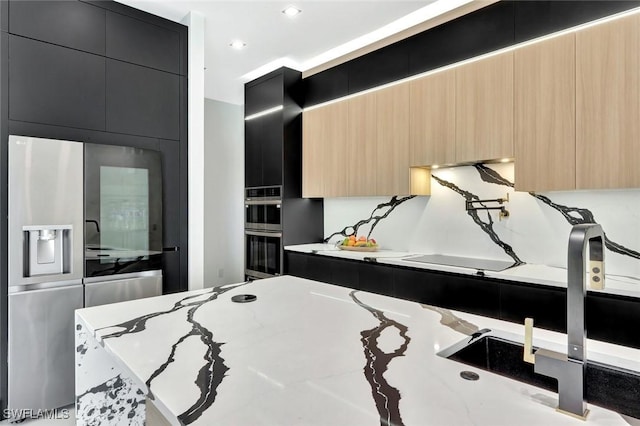 1041 Embers Pkwy W, Cape Coral, FL 33993 - kitchen featuring modern cabinets, stainless steel appliances, dark cabinetry, light stone counters, and light brown cabinetry