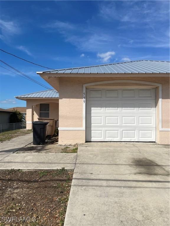 garage with driveway and fence