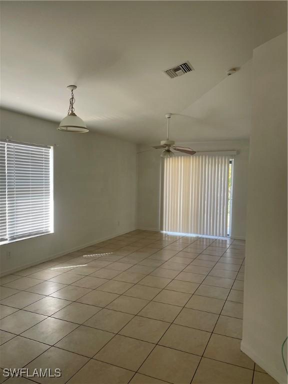 spare room with light tile patterned floors, ceiling fan, and visible vents