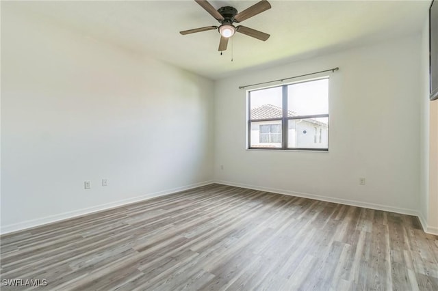 empty room featuring baseboards, a ceiling fan, and wood finished floors