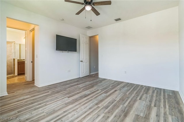 interior space featuring light wood-style floors, ceiling fan, baseboards, and visible vents