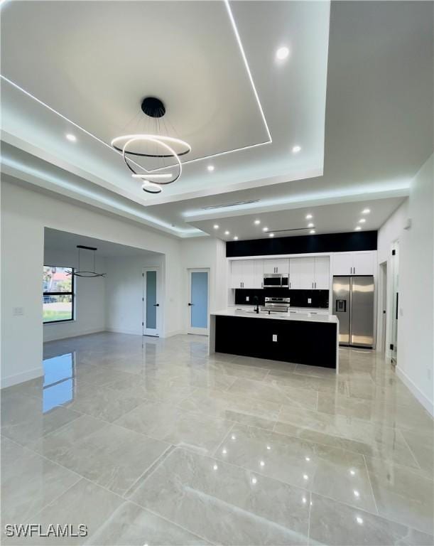 856 Jaguar Blvd, Lehigh Acres, FL 33974 - kitchen featuring open floor plan, light countertops, stainless steel appliances, and a raised ceiling