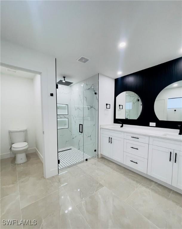 856 Jaguar Blvd, Lehigh Acres, FL 33974 - bathroom with a sink, a marble finish shower, baseboards, visible vents, and double vanity