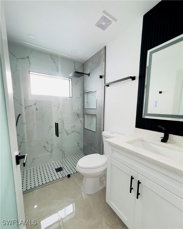 856 Jaguar Blvd, Lehigh Acres, FL 33974 - bathroom featuring toilet, vanity, a marble finish shower, and visible vents