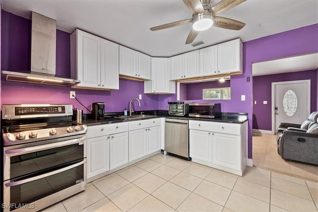 48 Victoria Dr, North Fort Myers, FL 33917 - kitchen with wall chimney range hood, a sink, dark countertops, and appliances with stainless steel finishes