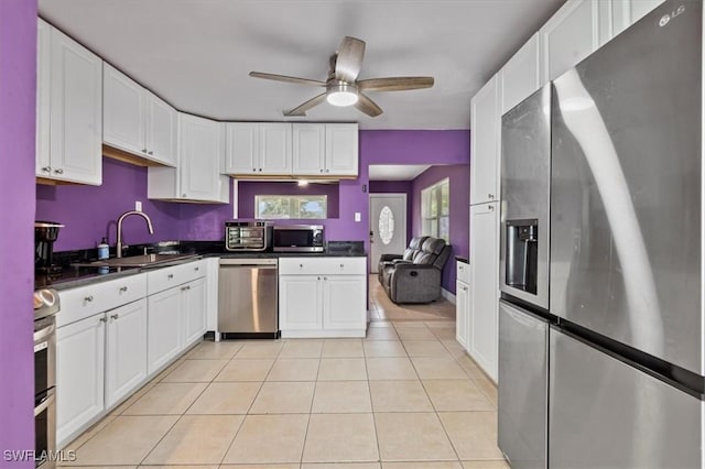 48 Victoria Dr, North Fort Myers, FL 33917 - kitchen featuring a sink, white cabinetry, appliances with stainless steel finishes, light tile patterned floors, and dark countertops