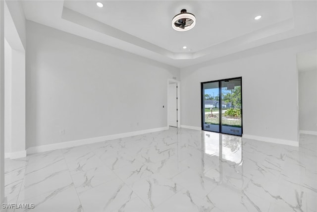 unfurnished room with marble finish floor, baseboards, recessed lighting, and a raised ceiling