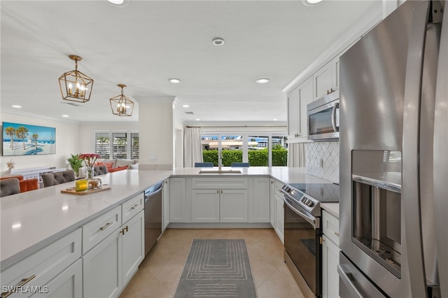 kitchen featuring light tile patterned flooring, light countertops, a sink, open floor plan, and stainless steel appliances