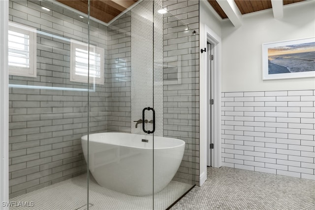 full bath with tile walls, a stall shower, tile patterned flooring, and a freestanding bath