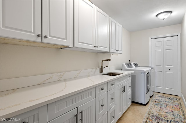 laundry area with cabinet space, a sink, and washer and clothes dryer