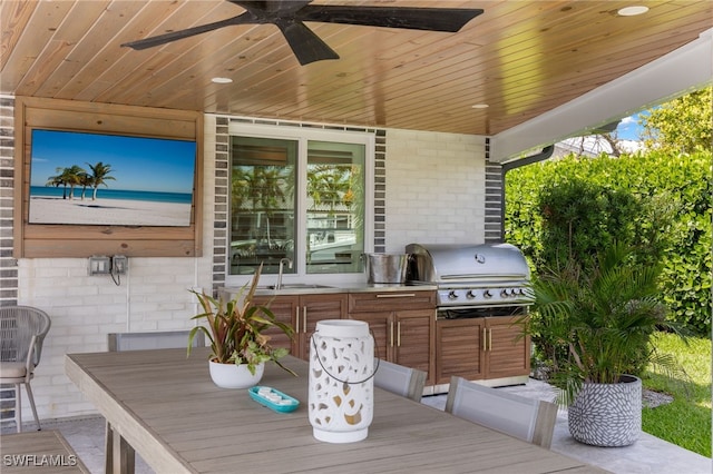 view of patio / terrace featuring a grill, outdoor dining space, a sink, and a ceiling fan