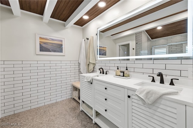 bathroom featuring tile walls, recessed lighting, a sink, beamed ceiling, and double vanity
