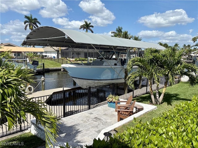 view of dock with fence, a water view, and a yard